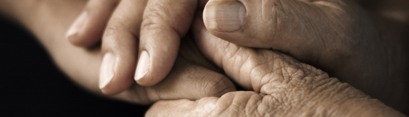 Elderly hands being held