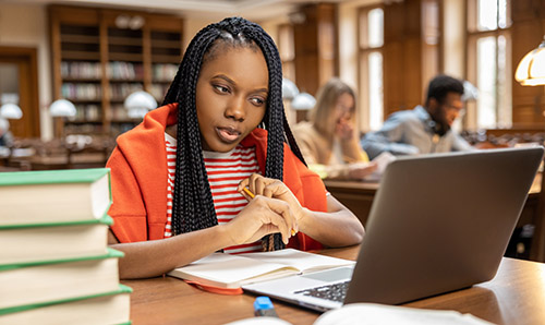 Long-haired young woman studying in the library